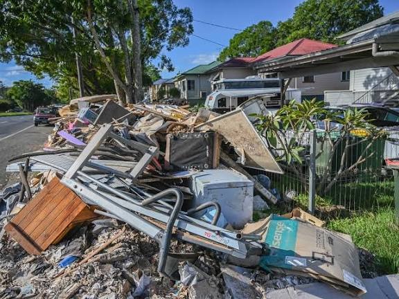 Pile of waterlogged drywall and flood-damaged structural building materials